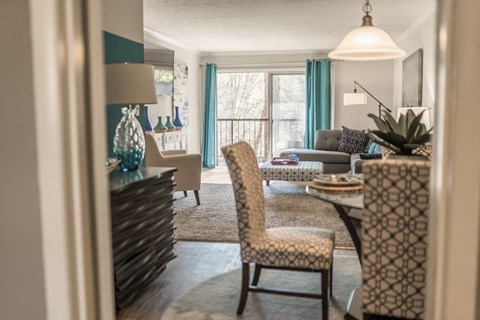 a living room and dining room with blue curtains and a window